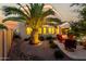Charming backyard with a palm tree, stone landscaping, two story home, covered patio, and cozy seating area at 3634 S Danielson Way, Chandler, AZ 85286