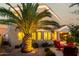Backyard features a palm tree, stone landscaping, two story home with a covered patio and comfortable seating at 3634 S Danielson Way, Chandler, AZ 85286