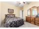 Spacious bedroom with carpet, a ceiling fan and a wooden dresser and mirror at 3634 S Danielson Way, Chandler, AZ 85286