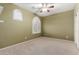 Empty bedroom featuring neutral carpet, shuttered windows and a ceiling fan at 3634 S Danielson Way, Chandler, AZ 85286