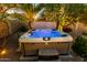 Relax in this backyard hot tub surrounded by lush greenery and beautiful outdoor lighting at 3634 S Danielson Way, Chandler, AZ 85286