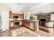 Modern kitchen with stainless steel appliances, wooden cabinets, and tile floors, flowing into the cozy living room at 3634 S Danielson Way, Chandler, AZ 85286