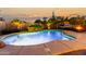 Beautiful pool with an elevated stone waterfall, lush landscaping, and an evening sky in the background at 3634 S Danielson Way, Chandler, AZ 85286