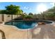 Sparkling pool featuring an elevated stone waterfall and lush landscaping, perfect for relaxation and outdoor fun at 3634 S Danielson Way, Chandler, AZ 85286