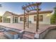 Paver patio features a pergola, planter bed, and cozy seating area in this home's backyard at 3753 E Ellis St, Mesa, AZ 85205