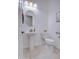 Bright half bathroom with a pedestal sink, neutral tile floors, and a modern round mirror with lighting at 3753 E Ellis St, Mesa, AZ 85205