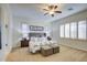 Relaxing main bedroom features plantation shutters, a ceiling fan, neutral color palette, and comfortable seating at 3753 E Ellis St, Mesa, AZ 85205