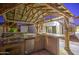 Covered outdoor kitchen with BBQ grill, mini fridge, and bar seating at 3753 E Ellis St, Mesa, AZ 85205