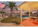 Inviting backyard featuring a pool with rock waterfall, covered patio, and lush artificial turf, perfect for relaxation at 3971 E Heather Ct, Gilbert, AZ 85234