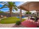 Inviting backyard featuring a pool with rock waterfall, covered patio, and lush artificial turf, perfect for relaxation at 3971 E Heather Ct, Gilbert, AZ 85234