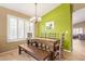 Bright dining room with large window, contemporary chandelier, and modern wood table with seating at 3971 E Heather Ct, Gilbert, AZ 85234