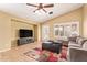 Cozy living room features tile floors, a modern ceiling fan, and a comfortable sectional sofa at 3971 E Heather Ct, Gilbert, AZ 85234