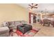 Comfortable living room with plush couch, leather ottoman, and modern ceiling fan at 3971 E Heather Ct, Gilbert, AZ 85234