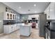 Charming kitchen with a kitchen island, modern appliances, and white cabinetry at 4019 W Charlotte Dr, Glendale, AZ 85310