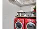 Laundry room features bright red washer and dryer units and wood shelving at 4019 W Charlotte Dr, Glendale, AZ 85310