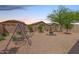Backyard featuring desert landscaping, a fire pit, and a fun swing set at 4136 W Palace Station Rd, New River, AZ 85087