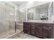 Bathroom with modern shower, neutral tile, vanity with storage, a window and contemporary countertops at 4136 W Palace Station Rd, New River, AZ 85087