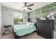 Bright bedroom with a unique ivy wall accent, ceiling fan, and large window at 4136 W Palace Station Rd, New River, AZ 85087