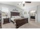 Main bedroom with large bed, matching nightstands, carpet floors, and a view to the ensuite bathroom at 4136 W Palace Station Rd, New River, AZ 85087