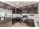 Kitchen featuring stainless steel appliances, dark wood cabinetry, and ample counter space for food preparation and cooking at 4136 W Palace Station Rd, New River, AZ 85087