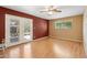 Bedroom features laminate flooring, a ceiling fan, and access to the backyard through glass doors at 4219 E Catalina Dr, Phoenix, AZ 85018