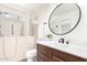 Updated bathroom features a walk-in tub, modern vanity, and round mirror at 4310 E Sacaton St, Phoenix, AZ 85044