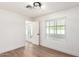 Bright bedroom with modern light fixture, wood floors, and adjacent sun room at 4310 E Sacaton St, Phoenix, AZ 85044