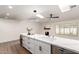 Kitchen featuring white cabinets, countertops, skylights, and an island with a built-in wine fridge at 4310 E Sacaton St, Phoenix, AZ 85044