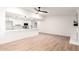 Open concept living room with wood-look floors connecting to the kitchen area with white cabinetry at 4310 E Sacaton St, Phoenix, AZ 85044