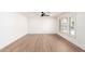 Large living room with hardwood floors, ceiling fan, white walls, and bright natural light at 4310 E Sacaton St, Phoenix, AZ 85044