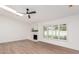 Bright living room with a skylight, ceiling fan, white brick fireplace, and wood-look flooring at 4310 E Sacaton St, Phoenix, AZ 85044