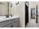 This bathroom features a vanity with a black faucet and a shower with a black and white shower curtain at 4512 S Ferric Ave, Mesa, AZ 85212