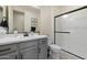 Neutral bathroom with a gray vanity, framed mirror and glass enclosed shower at 4512 S Ferric Ave, Mesa, AZ 85212