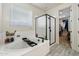 Bright bathroom with a glass shower, soaking tub, and tile flooring at 4512 S Ferric Ave, Mesa, AZ 85212