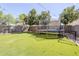 A backyard with artificial turf, large shade trees and a trampoline at 45543 W Guilder Ave, Maricopa, AZ 85139