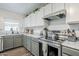 This kitchen features gray cabinetry, stainless steel appliances, and a marble countertop and backsplash at 45543 W Guilder Ave, Maricopa, AZ 85139