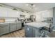 Cozy kitchen featuring white upper cabinets, gray lower cabinets, stainless appliances, and a marble countertop island at 45543 W Guilder Ave, Maricopa, AZ 85139