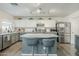 Bright kitchen featuring a gray island with marble countertop, stainless appliances, and white cabinetry at 45543 W Guilder Ave, Maricopa, AZ 85139