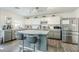 Modern kitchen featuring an island with bar stools, stainless appliances, and stylish lighting at 45543 W Guilder Ave, Maricopa, AZ 85139