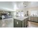 Spacious kitchen featuring gray cabinets, marble countertops, stainless appliances, and an open view into the living area at 45543 W Guilder Ave, Maricopa, AZ 85139