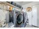 A full laundry room featuring a washer, dryer, shelving and storage at 45543 W Guilder Ave, Maricopa, AZ 85139