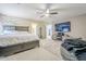 Spacious main bedroom featuring a ceiling fan, large bed, and ensuite bathroom entrance at 45543 W Guilder Ave, Maricopa, AZ 85139