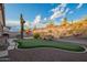 View of landscaped backyard featuring putting green, desert plants and mountain views at 4615 S Primrose Dr, Gold Canyon, AZ 85118