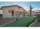 Backyard featuring a putting green, built-in grill, and desert landscaping, under a sunny blue sky at 4615 S Primrose Dr, Gold Canyon, AZ 85118