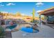 Beautiful backyard with a sparkling pool, waterfall feature, cacti and desert landscaping at 4615 S Primrose Dr, Gold Canyon, AZ 85118