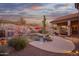 Desert backyard oasis featuring a sparkling pool, mature cacti, and a covered patio, under a colorful sky at 4615 S Primrose Dr, Gold Canyon, AZ 85118