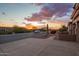 A street view showcases well-maintained landscaping, sidewalks, and a glimpse of a desert sunset in the background at 4615 S Primrose Dr, Gold Canyon, AZ 85118