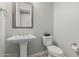 Powder room with pedestal sink, stylish mirror, and modern fixtures at 5653 E Sayan St, Mesa, AZ 85215