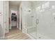 Modern bathroom with glass enclosed shower, bench, and a walk-in closet at 5653 E Sayan St, Mesa, AZ 85215