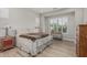 Cozy bedroom features a queen bed, wood floors, and a window with shutters at 5653 E Sayan St, Mesa, AZ 85215